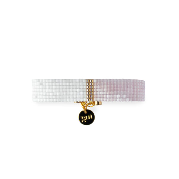 Elegant white and pink beaded bracelet with a gold charm on a white background.