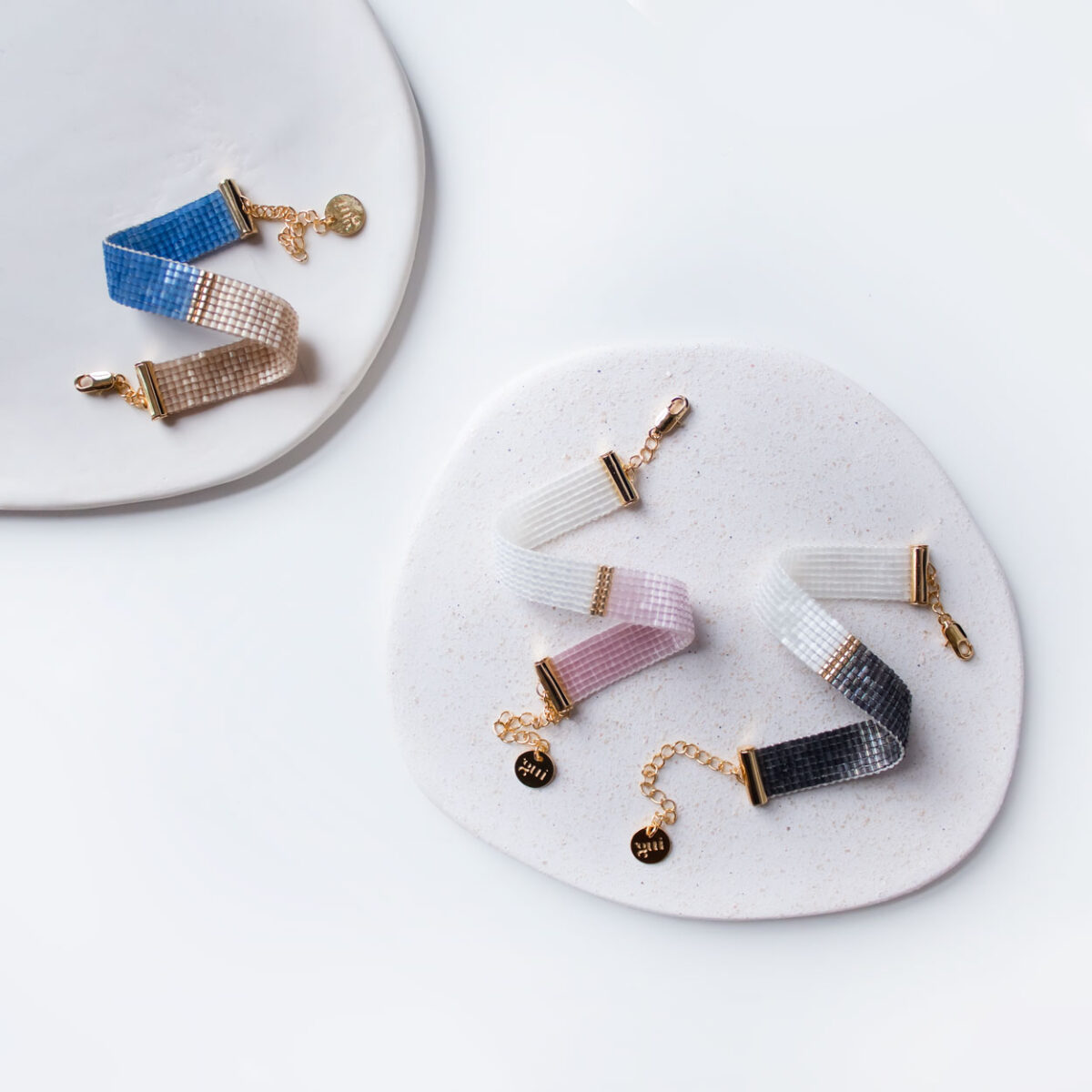 Elegant bracelets displayed on a white ceramic plate.
